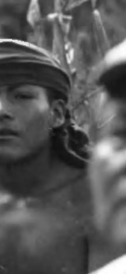 Closer black-and-white view of the young man in a headband gazing past the blurred older man in a cap.